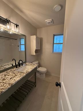 Killeen house for rent - a bathroom with a sink and a toilet and a mirror