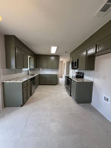 Killeen house for rent - an empty kitchen with stainless steel appliances and gray cabinets
