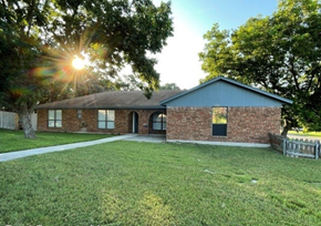 Killeen house for rent - the front of a brick house with a yard and the sun shining behind it