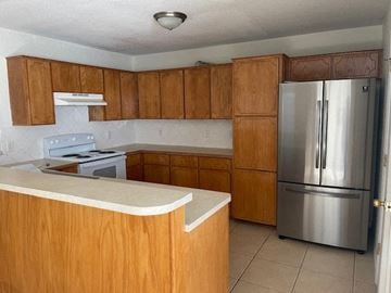 Killeen apartment for rent - a kitchen with wooden cabinets and a stainless steel refrigerator