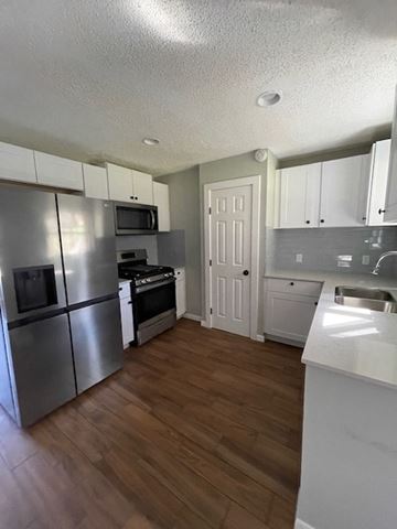 Killeen house for rent - a kitchen with stainless steel appliances and white cabinets