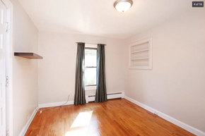 Comstock Park house for rent - an empty living room with a window and wood floors
