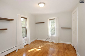 Comstock Park house for rent - an empty room with two windows and a wooden floor