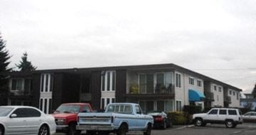 Lynnwood apartment for rent - an apartment building with trucks parked in a parking lot