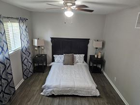 Killeen apartment for rent - A bedroom with a bed, nightstands, and a ceiling fan.