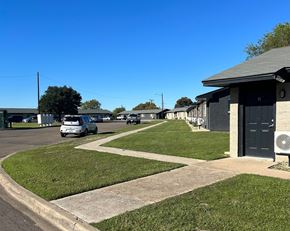 Killeen apartment for rent - A car is parked on the side of a road in front of a building.