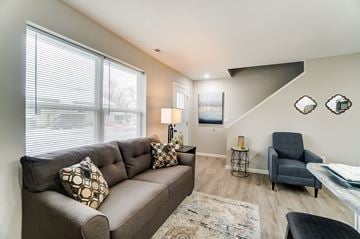Lima apartment for rent - A living room with a grey couch and a black chair.