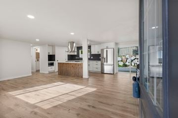 Bothell house for rent - a kitchen and living room with white walls and wood floors