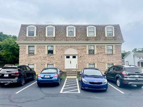 New Albany apartment for rent - A parking lot with cars and a building in the background.