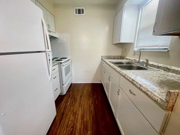 New Albany apartment for rent - A kitchen with a white fridge, sink and cabinets.