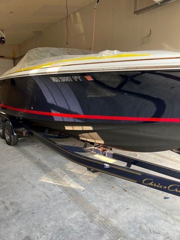 Naples house for rent - A boat with a black hull and red and yellow stripes is being towed by a trailer.