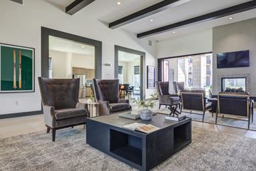 Denver apartment for rent - A modern living room with a black coffee table and brown leather chairs.
