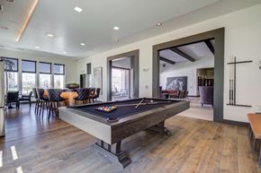 Denver apartment for rent - A pool table is in the middle of a room with a wooden floor.