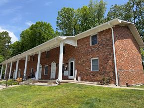 Irvine apartment for rent - a brick house with white columns and a lawn