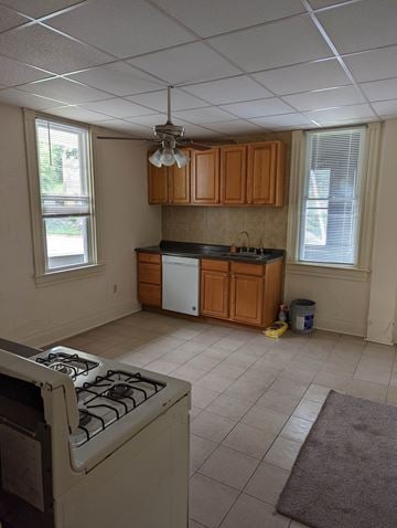 White Oak house for rent - A kitchen with a white stove top oven and a white dishwasher.