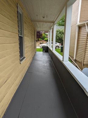 White Oak house for rent - A long, narrow hallway with a black floor and wooden walls.