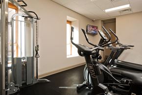 Albany apartment for rent - a gym with exercise equipment and a tv on the wall