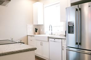Dawson Creek apartment for rent - a white kitchen with stainless steel appliances and white cabinets