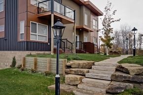 Dawson Creek apartment for rent - the exterior of a home with stone steps and a sidewalk