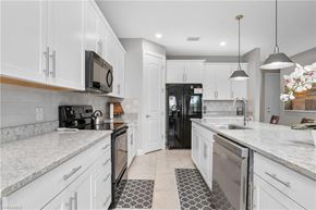 Estero house for rent - a large kitchen with white cabinets and a sink