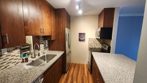 Richmond apartment for rent - a kitchen with granite counter tops and wooden cabinets