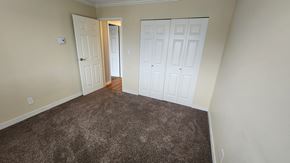 Richmond apartment for rent - a bedroom with two closets and a carpeted floor