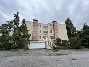 Richmond apartment for rent - the front of a building with a driveway and a garage door