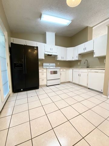 Lafayette house for rent - A kitchen with a black refrigerator, white cabinets, and a white oven.