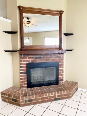 Lafayette house for rent - A brick fireplace with a mirror above it.