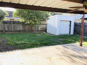 Lafayette house for rent - A backyard with a shed and a fence.