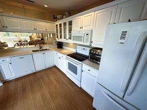 Bradenton house for rent - a kitchen with white cabinets and stainless steel appliances