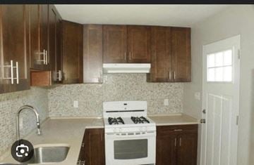 Severn house for rent - an empty kitchen with wooden cabinets and a white stove