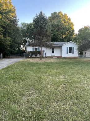 Clarksville house for rent - A white house with a grey roof and a green lawn in front.