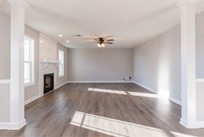 Clarksville house for rent - an empty living room with a ceiling fan and a fireplace