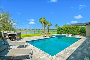 Estero house for rent - a swimming pool with palm trees in the backyard of a house