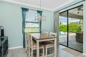 Estero house for rent - a dining room with a table and chairs and a sliding glass door