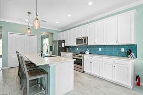 Estero house for rent - a kitchen with white cabinets and a table and chairs