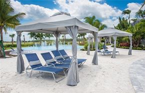 Estero house for rent - a group of beach chairs and umbrellas next to a pool