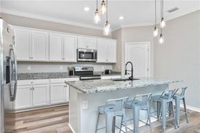 Estero house for rent - a kitchen with white cabinets and a counter top