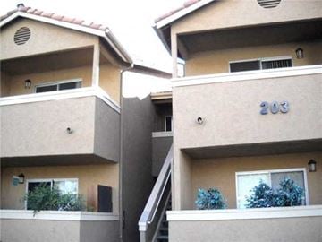 San Marcos apartment for rent - Two tan buildings with the number 203 on the side of the right one.