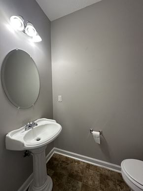 Clarksville house for rent - a bathroom with a sink and a mirror and a toilet