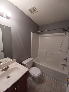 Clarksville house for rent - A bathroom with a toilet, sink, and bathtub.