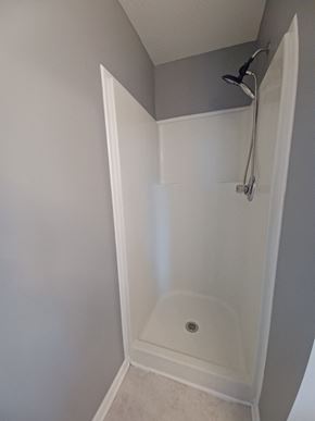Clarksville house for rent - A white shower stall with a drain in the middle.