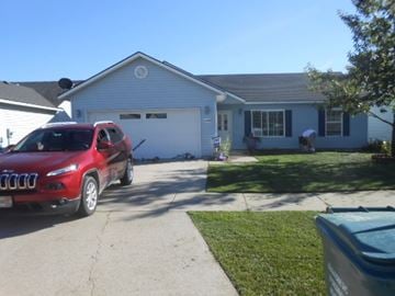 Rathdrum house for rent - a house with a red car parked in front of it