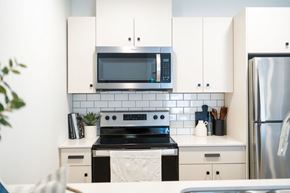 Winnipeg apartment for rent - a kitchen with white cabinets and a black stove