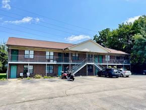Shepherdsville apartment for rent - a building with a parking lot and a motorcycle in front of it
