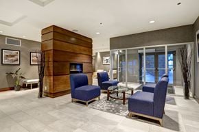 Kanata apartment for rent - a lobby with blue chairs and a fire place