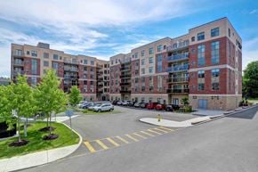 Kanata apartment for rent - a view of a large apartment building with a parking lot
