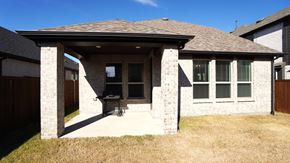 Royse City house for rent - A house with a covered patio and a lawn.