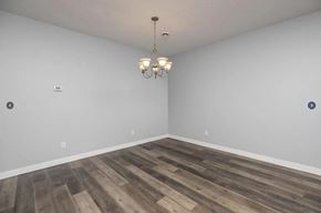 Rochester apartment for rent - an empty living room with wood flooring and a chandelier